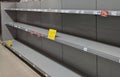 Empty toilet paper shelves in supermarket after panic buying due to outbreaking coronavirus, translation:`There is no stock availa