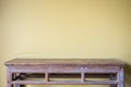 Empty top vintage wooden table and yellow cement wall background