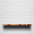 Empty top of wooden shelf with white brick wall. Royalty Free Stock Photo