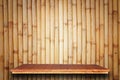 Empty top wooden shelves and bamboo wall background Royalty Free Stock Photo