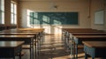 Empty traditional classroom featuring rows of wooden desks and a blackboard illuminated by dramatic sunlight streaming through Royalty Free Stock Photo
