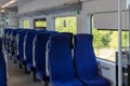 an empty train car with blue upholstered chairs