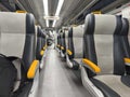 an empty train carriage with rows of seats Royalty Free Stock Photo