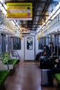 the empty train cars have a green seats on one side