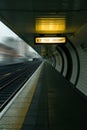 Empty train station platform illuminated by overhead lights indicating uncertainty about next train arrival time in urban Royalty Free Stock Photo