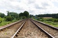 An empty train track, there are 2 tracks leading to a vanishing point on the horizon in rural countryside Royalty Free Stock Photo