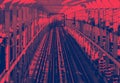 Empty train tracks across the Williamsburg Bridge from Brooklyn to Manhattan in New York City with red blue duotone colors Royalty Free Stock Photo