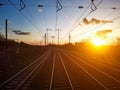 Empty train tracks reflecting sunset light