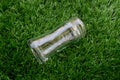Empty transparent glass bottle lay down on the grass Royalty Free Stock Photo