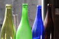 Empty and transparent glass bottles standing in a row, green, blue and brown Royalty Free Stock Photo