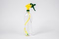 Empty transparent plastic bottle with bright yellow and green atomizer, set on white background. Indoors, copy space Royalty Free Stock Photo