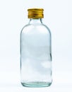 Empty transparent round glass bottle with closed aluminum yellow cap on white background with blank label and copy space. Royalty Free Stock Photo