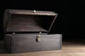 Empty treasure chest on table against black background