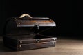 Empty treasure chest on wooden table against black background. Space for text