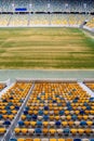 Empty tribune of soccer or football stadium field with old faded grass