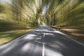 Empty two-lane country road through woodland with motion blur Royalty Free Stock Photo