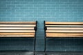 Empty two wooden bench on green brick wall background. Waiting for someone to full fill empty wooden chair. Brown wooden bench Royalty Free Stock Photo