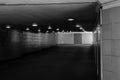 Empty underground passage lit by lamps black and white image