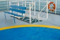 Empty upper deck with blue wooden bench and helicopter pickup point on Greek ferry