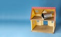 Empty used tin can inside toy house on blue background, home garbage or trash problem, concept zero waste, copy space Royalty Free Stock Photo