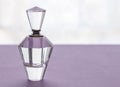 Empty vintage crystal glass perfume bottle with stopper on lilac Royalty Free Stock Photo