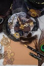 An empty vintage postcard for a close-up message, surrounded by women`s jewelry, lace with fur and steampunk gears mechanisms and