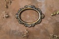 Empty vintage round photo frame and twigs of dried flowers on decorative brown backdrop. Royalty Free Stock Photo