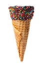 Empty wafer cone with chocolate icing and colorful sprinkles isolated on white background