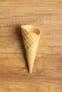 Empty wafer cone. Sweet ice cream cornet on wooden table. Top view