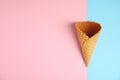 Empty wafer ice cream cone on color background. Space for text Royalty Free Stock Photo