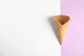 Empty wafer ice cream cone on color background, top view
