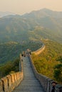 Empty walkway atop the Great Wall running across the vast green mountains.