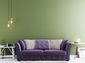 Empty wall for mock up on a green wall in modern hipster interior with violet sofa and white table. Royalty Free Stock Photo