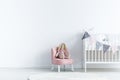 Empty wall next a to chair with a rabbit and crib with triangles Royalty Free Stock Photo