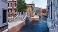 Empty water canal with old stone bridge in Venice