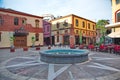 An empty waterfountain and old buildings