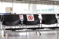 Empty waiting room at an airport during COVID-19 pandemic with social distancing signs on chairs