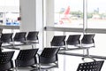 Empty wating room at an airport during COVID-19 pandemic with social distancing signs on chairs