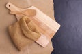 empty wheat flour sacks With wooden chopping boards on the table, black background - top view