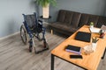 Empty wheelchair in black with large wheels and manual controls on home background. Barrier-free area. Nobody. Apartment