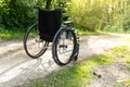 Empty wheelchair parked in park, health care concept, with sun flare Royalty Free Stock Photo