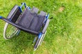 Empty wheelchair standing on grass in hospital park waiting for patient services Royalty Free Stock Photo