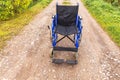 Empty wheelchair standing on road waiting for patient services. Wheel chair for people person with disability parked outdoor. Royalty Free Stock Photo