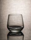empty whiskey glass with reflection on textured gray background Royalty Free Stock Photo
