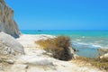 Empty white beach with old ruins of abandoned stone house on the rocks and summer blue sky and sea in background near Argento in S Royalty Free Stock Photo