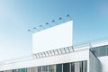 Empty white billboard with on shopping mall exterior. Blue sky background. Mock up place for your advertisement.