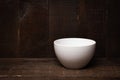Empty white bowl on rastic wooden background. Royalty Free Stock Photo
