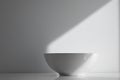 Empty White Bowl on a Textured White Surface with Sunlight A minimalist still life image ideal for product placement or design Royalty Free Stock Photo