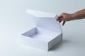 Empty White Box Being Opened by a Hand Against a Plain Background Royalty Free Stock Photo