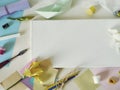 Empty white canvas, art materials, fresh flowers, decor on a light background Royalty Free Stock Photo